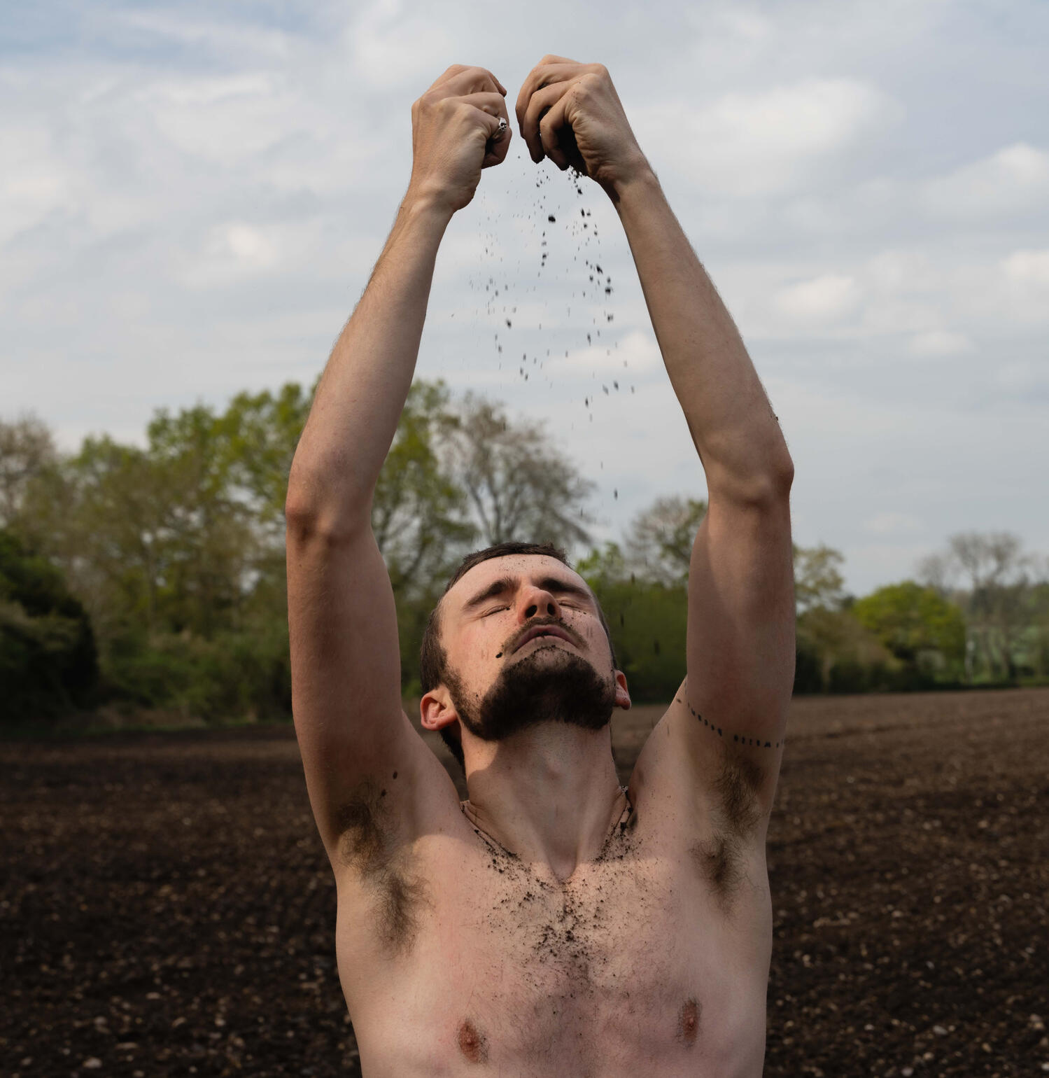 Shaun Hill Embodied Woodland Poet Shaun performing somatic movement behind the leaves of a tree.